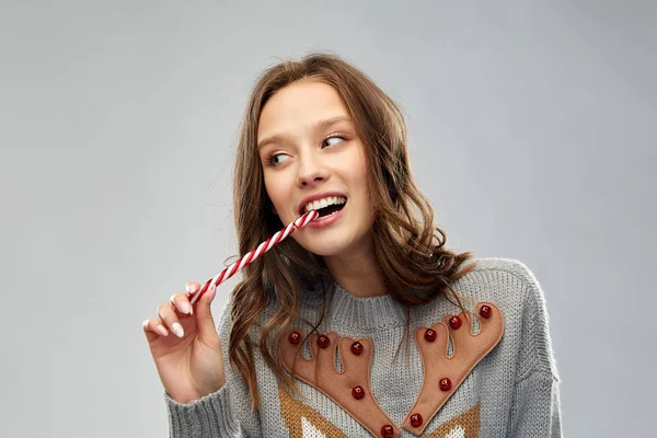 Frau im Weihnachtspulli isst Zuckerrohr — Stockfoto