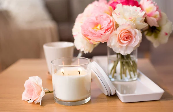 Vela ardiente y ramo de flores en la mesa en casa —  Fotos de Stock