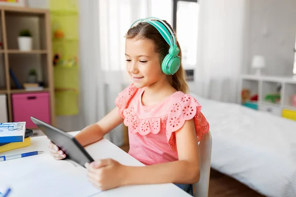 Ragazza in cuffia con tablet a casa — Foto Stock