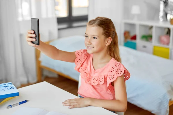 Glad flicka med smartphone tar selfie hemma — Stockfoto