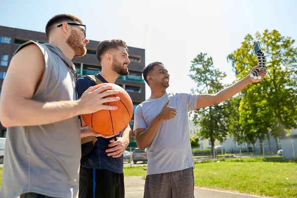 Hombres felices tomando selfie en el patio de baloncesto — Foto de Stock
