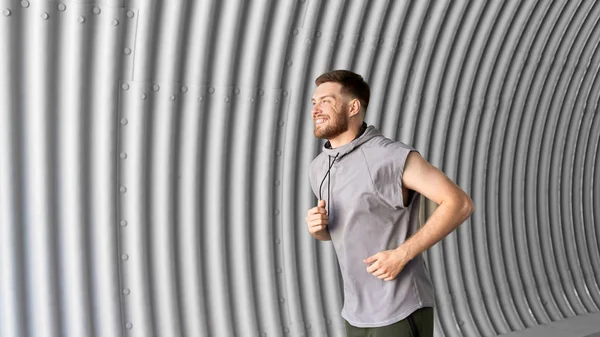 Sportlicher junger Mann läuft in Tunnel — Stockfoto