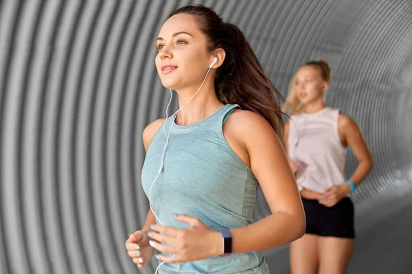 Femmes ou amies avec écouteurs en marche — Photo