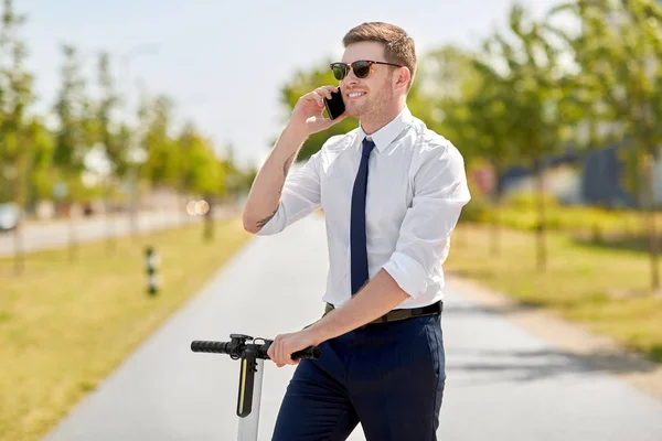 Geschäftsmann mit Roller telefoniert mit Smartphone — Stockfoto