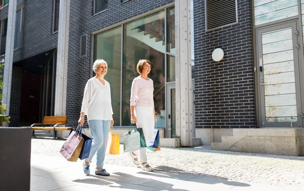 Senior vrouwen met boodschappentassen wandelen in de stad — Stockfoto