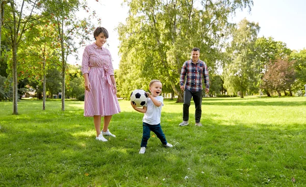 Família feliz jogando futebol no parque de verão — Fotografia de Stock
