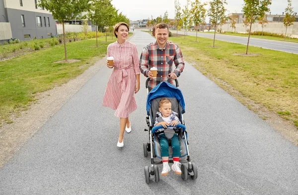 Familie met baby in kinderwagen en koffie in de stad — Stockfoto
