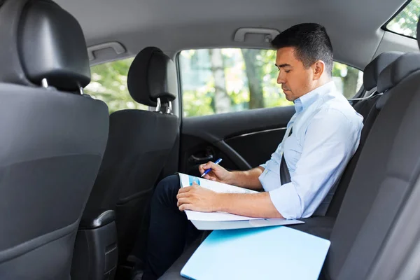 Hombre de negocios con café en el asiento trasero del coche — Foto de Stock