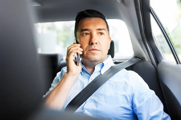 Пассажир мужчина звонит на смартфон в машине такси — стоковое фото