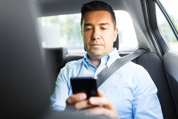 Passenger or businessman using smartphone in car — ストック写真