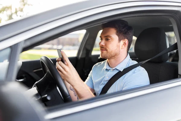 Homme conduisant une voiture et utilisant un smartphone — Photo