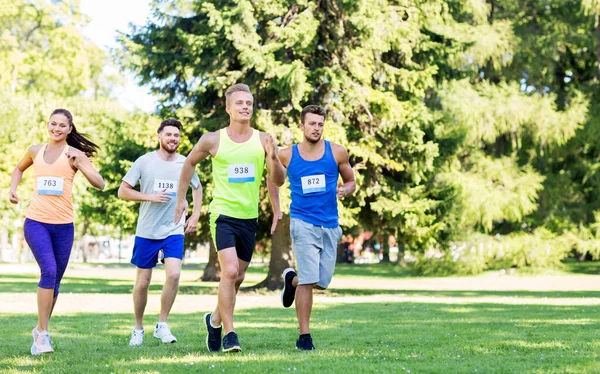 Feliz joven deportistas carreras ingenio insignia números — Foto de Stock