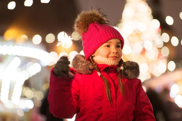Happy girl with sparkler at christmas market — Stock Photo, Image