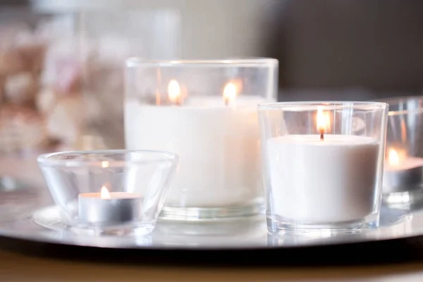 Jak vypálit bílé vonné svíčky na tácu na stole — Stock fotografie