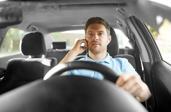 Homem ou motorista com fones de ouvido sem fio carro de condução — Fotografia de Stock