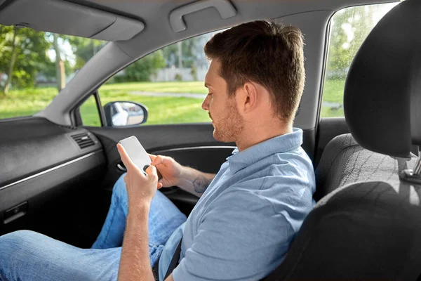 Passager masculin utilisant un smartphone dans une voiture de taxi — Photo