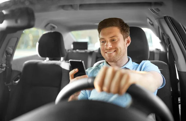 Homem dirigindo carro e usando smartphone — Fotografia de Stock
