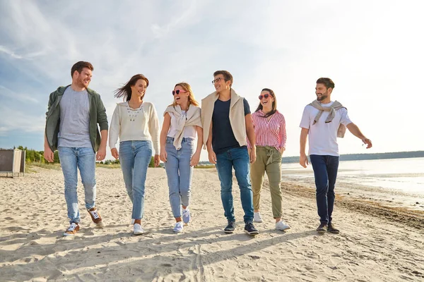 Amigos felices caminando por la playa de verano — Foto de Stock