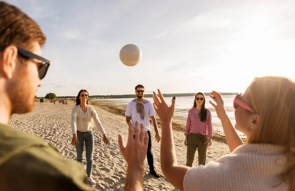 Przyjaciele grający w siatkówkę na plaży latem — Zdjęcie stockowe