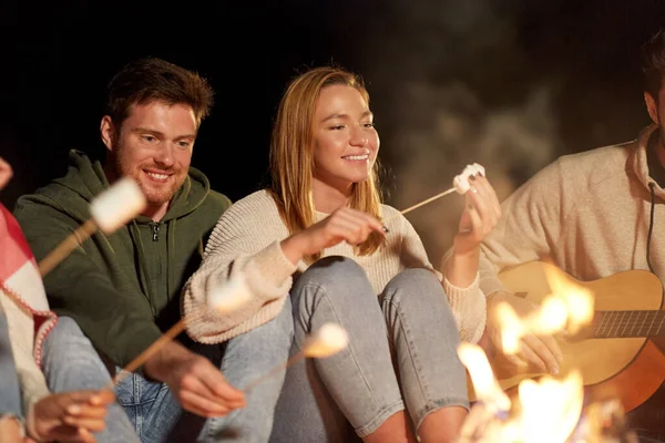 Vrienden roosteren marshmallow en gitaar spelen — Stockfoto