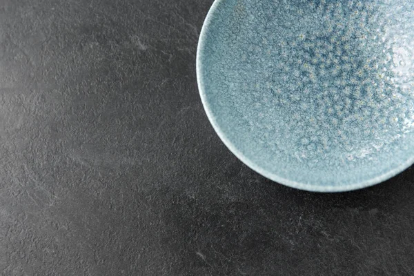 Close up of blue ceramic plate on slate background — Stock Image Close up of blue ceramic plate on slate background Stock Picture