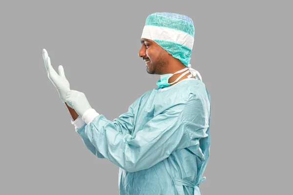 Indiana masculino médico ou cirurgião colocando luva em — Fotografia de Stock