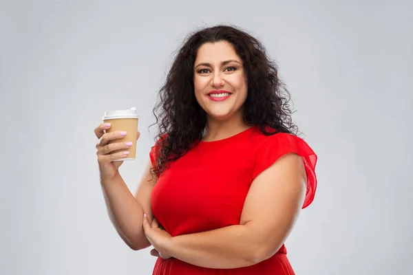Vrouw in rode jurk houden afhaalkoffie kop — Stockfoto