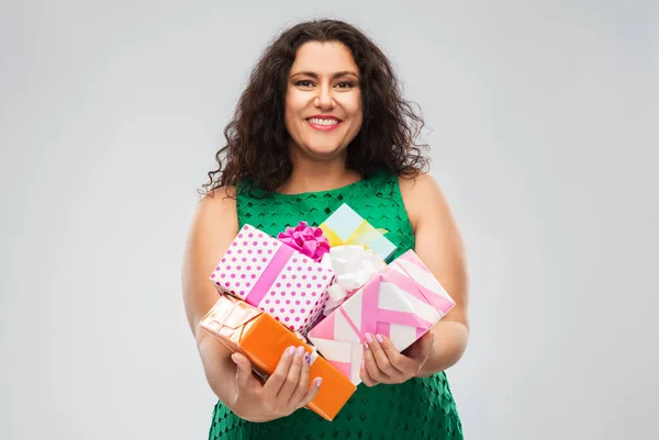 Happy woman in green dress holding gift boxes — Stock Photo, Image