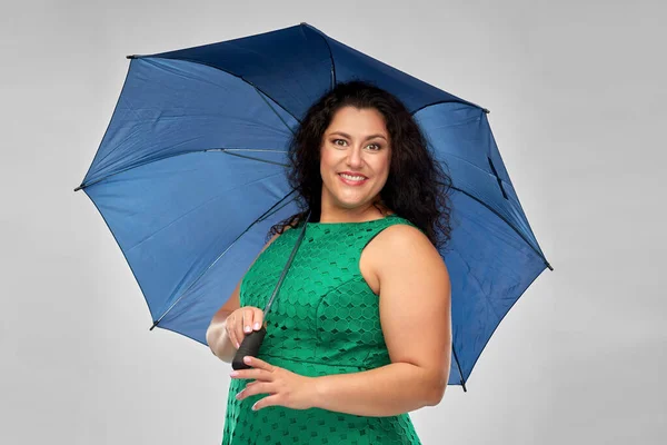 Χαρούμενη γυναίκα με πράσινο φόρεμα με μπλε ομπρέλα — Φωτογραφία Αρχείου