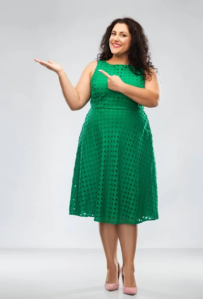 Glückliche Frau in Grün, die mit dem Finger auf etwas zeigt — Stockfoto