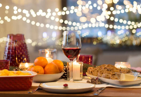 Glas rött vin och mat på julbordet — Stockfoto