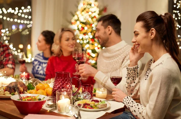 Amigos felices teniendo la cena de Navidad en casa —  Fotos de Stock