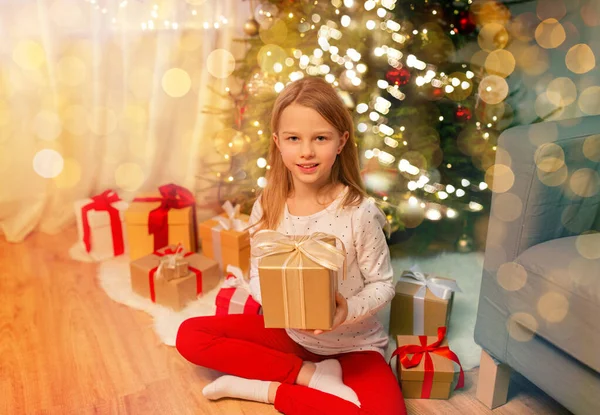 Χαμογελαστό κορίτσι με τα χριστουγεννιάτικα δώρα στο σπίτι — Φωτογραφία Αρχείου