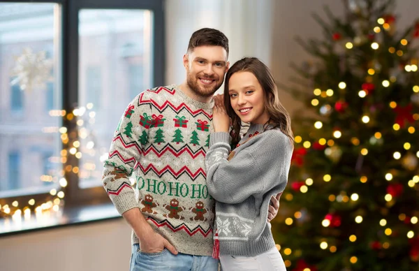 Happy couple at christmas ugly sweater party — Stock Photo, Image