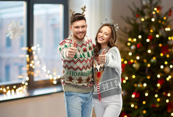 一对穿着圣诞礼物的丑陋的毛衣的夫妇竖起了大拇指 — 图库照片