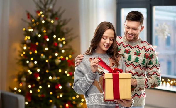 Szczęśliwa para w swetrach świątecznych z pudełkiem prezentów — Zdjęcie stockowe