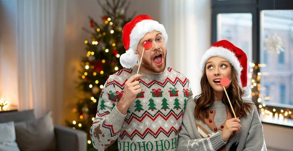 Pareja con accesorios de fiesta de Navidad en suéteres feos —  Fotos de Stock