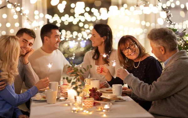 Família com sparklers tendo jantar em casa — Fotografia de Stock