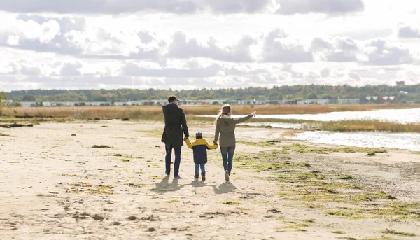 Felice passeggiata in famiglia lungo la spiaggia autunnale — Foto Stock