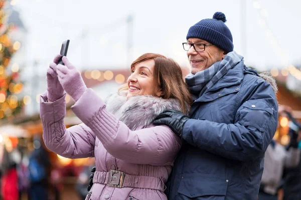 Yılbaşı pazarında selfie çeken yaşlı çift. — Stok fotoğraf