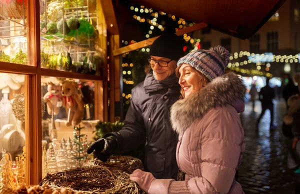 Heureux couple de personnes âgées étreignant au marché de Noël — Photo