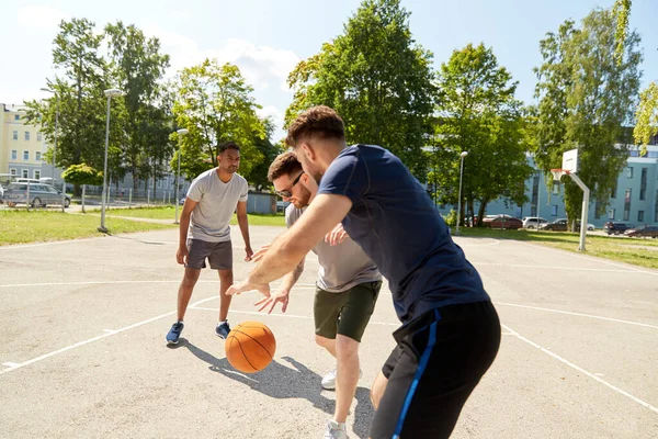 Skupina mužských přátel hrající pouliční basketbal — Stock fotografie