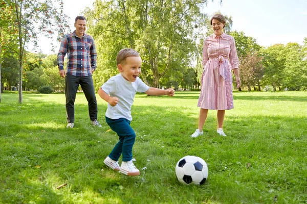 Familia feliz jugando al fútbol en el parque de verano —  Fotos de Stock