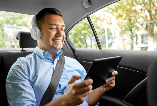 Passageiro com fones de ouvido usando tablet pc no carro — Fotografia de Stock