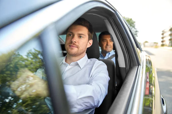 Conducente di sesso maschile guida di auto con passeggero — Foto Stock