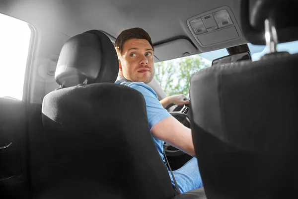 Uomo o conducente guida auto e guardando indietro — Foto Stock