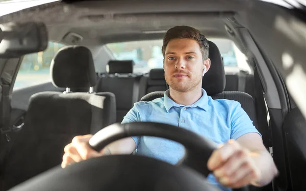 Человек или водитель с беспроводными наушниками за рулем автомобиля — стоковое фото