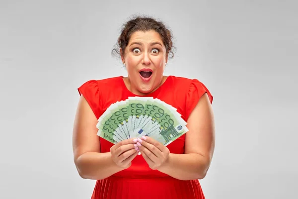 Mujer conmocionada sosteniendo cientos de billetes de dinero — Foto de Stock