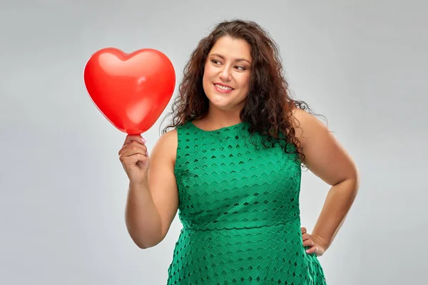 Mulher feliz segurando balão em forma de coração vermelho — Fotografia de Stock