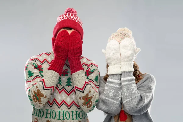 Couple in ugly sweaters and mittens on christmas — Stock Photo, Image